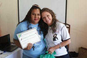Consócia Márcia, presidente do CMB, entrega diploma a uma das participantes.